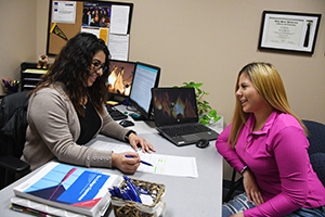 Valerie Ruiz in Admissions with a student.